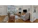 Cozy living room with a fireplace, large windows, and comfortable seating at 12227 Orchardgrass Ln, Raleigh, NC 27614