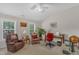 Well-lit home office with comfortable seating, a desk, and plenty of natural light from the windows at 12227 Orchardgrass Ln, Raleigh, NC 27614