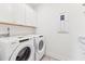 A laundry room with side-by-side washer and dryer and upper cabinets at 1625 Plover Cir, Fuquay Varina, NC 27526