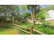 Landscaped front yard showcasing the home's exterior with mature trees and a wooden fence at 1815 Hawthorne Ln, Burlington, NC 27215