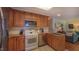 Well-lit kitchen featuring wooden cabinetry, tile backsplash, and stainless-steel appliances at 1815 Hawthorne Ln, Burlington, NC 27215