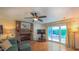 Bright living room featuring brick fireplace, ceiling fan, and a glass sliding door at 1815 Hawthorne Ln, Burlington, NC 27215