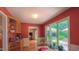 Bright sunroom with windows overlooking the landscaped backyard, adjacent to a kitchenette at 1815 Hawthorne Ln, Burlington, NC 27215