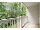 Covered balcony with white railing overlooking lush green trees and offering peaceful outdoor space at 1851 Trailwood Heights Ln, Raleigh, NC 27603