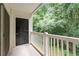 View of private outdoor balcony with black door and white rails overlooking lush greenery at 1851 Trailwood Heights Ln, Raleigh, NC 27603