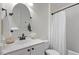Bright bathroom with a white vanity, round mirror, and shower with a curtain at 1851 Trailwood Heights Ln, Raleigh, NC 27603