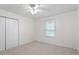 A sunny bedroom with carpet, a ceiling fan, closet and a large window at 1851 Trailwood Heights Ln, Raleigh, NC 27603