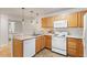 Modern kitchen with stainless steel appliances, tile flooring and warm-toned cabinets at 1851 Trailwood Heights Ln, Raleigh, NC 27603