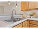 Stainless steel sink with modern faucet paired with warm wood cabinets and pendant lights at 1851 Trailwood Heights Ln, Raleigh, NC 27603