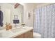 Well-lit bathroom featuring a modern vanity with sleek fixtures and a stylish patterned shower curtain at 19 Learned Pl, Durham, NC 27705