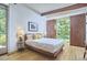 Bright bedroom with a view, features a modern bed, wood floors and built-in wood cabinets at 19 Learned Pl, Durham, NC 27705
