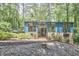 Inviting two-story home with blue siding, brick accents and large windows surrounded by beautiful landscaping and trees at 19 Learned Pl, Durham, NC 27705