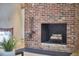 Close up of a charming red brick fireplace with mantle and hearth at 19 Learned Pl, Durham, NC 27705