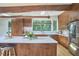 Large kitchen with wood cabinets, stainless steel appliances, a spacious island, and natural light coming through the large window at 19 Learned Pl, Durham, NC 27705
