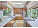 Contemporary kitchen with natural wood cabinetry, white countertops, stainless steel appliances, and a window with a wooded view at 19 Learned Pl, Durham, NC 27705