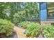 Landscaped yard with flowers, a gravel path, and views of the home's blue siding and wooden deck at 19 Learned Pl, Durham, NC 27705