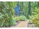 Partial view of home with blue siding, a gravel path, and views of the home's entry surrounded by flowers at 19 Learned Pl, Durham, NC 27705