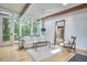Well-lit living area features exposed beams, natural light, and a view of the backyard through large windows at 19 Learned Pl, Durham, NC 27705