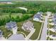 Aerial view of the neighborhood with a pond, golf course, and mature trees at 200 Baskerville Ct, Holly Springs, NC 27540