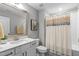Bathroom with a large mirror, white vanity, and shower with decorative curtain at 200 Baskerville Ct, Holly Springs, NC 27540