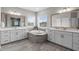 Luxurious primary bathroom with double vanities, soaking tub, and tiled floors at 200 Baskerville Ct, Holly Springs, NC 27540