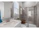Bright bathroom with gray tiling, glass enclosed shower, white quartz countertop, and silver framed mirror at 200 Baskerville Ct, Holly Springs, NC 27540