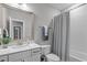Bathroom with white vanity, a framed mirror, and a tub with shower and patterned curtain at 200 Baskerville Ct, Holly Springs, NC 27540