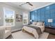 Comfortable bedroom features a decorative blue accent wall, soft rug, and natural light from two large windows at 200 Baskerville Ct, Holly Springs, NC 27540