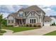 Beautiful two-story home featuring stone accents, gray siding, attached garage and a manicured lawn at 200 Baskerville Ct, Holly Springs, NC 27540