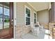 Inviting front porch with stone details, rocking chairs, and decorative pillows at 200 Baskerville Ct, Holly Springs, NC 27540