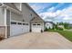 Three-car garage with a spacious driveway and well-manicured lawn at 200 Baskerville Ct, Holly Springs, NC 27540