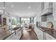 Open-concept kitchen with stainless appliances flows into dining and living spaces with lots of natural light at 200 Baskerville Ct, Holly Springs, NC 27540