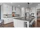 Modern kitchen boasts white cabinetry, stylish lighting fixtures, and a large island with seating at 200 Baskerville Ct, Holly Springs, NC 27540