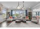 Open living room featuring large windows, comfortable seating, and built-in shelving filled with decorations at 200 Baskerville Ct, Holly Springs, NC 27540