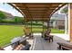 Inviting backyard patio area under a pergola, including a cozy fire pit at 204 Franconia Way, Apex, NC 27502