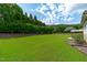 Expansive backyard featuring lush green lawn, mature trees, and well-maintained landscaping at 204 Franconia Way, Apex, NC 27502