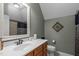 Bathroom with decorative mirror, wood-toned cabinets, neutral color palette and a shower at 204 Franconia Way, Apex, NC 27502