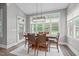 Bright dining room area with backyard views, ample windows, and a modern light fixture at 204 Franconia Way, Apex, NC 27502