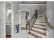 Spacious foyer featuring marble flooring, staircase with decorative iron railing, and access to a powder room at 204 Franconia Way, Apex, NC 27502