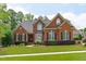 Charming brick two-story home with manicured lawn and mature landscaping, featuring black shutters and a bay window at 204 Franconia Way, Apex, NC 27502