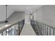 Long hallway featuring carpet, staircase, decorative railings and access to many rooms at 204 Franconia Way, Apex, NC 27502