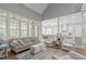 Bright living room featuring a vaulted ceiling and large windows with a view to the kitchen and dining area at 204 Franconia Way, Apex, NC 27502