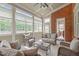 Inviting sunroom with a brick accent wall, large windows, and cozy seating, perfect for relaxation and enjoying natural light at 204 Franconia Way, Apex, NC 27502
