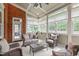Bright sunroom with brick accent wall, multiple windows, and comfortable seating for relaxing or entertaining at 204 Franconia Way, Apex, NC 27502