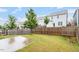 Spacious backyard featuring lush green grass, mature trees, and a wooden privacy fence at 212 Sea Trail St, Hillsborough, NC 27278