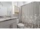 Bathroom featuring granite vanity, shower/tub combo, and toilet with white floral curtain at 212 Sea Trail St, Hillsborough, NC 27278