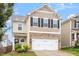 Inviting two-story home boasts stylish neutral siding, black shutters, and an attached two-car garage at 212 Sea Trail St, Hillsborough, NC 27278