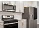 Close up of the kitchen with stainless steel appliances, white subway tile, and granite countertops at 212 Sea Trail St, Hillsborough, NC 27278