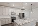 Bright kitchen features white cabinets, stainless steel appliances, granite countertops and large kitchen island at 212 Sea Trail St, Hillsborough, NC 27278