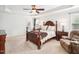 Spacious bedroom with a tray ceiling, ceiling fan, and elegant dark wood furniture set at 214 Ashdown Forest Ln, Cary, NC 27519